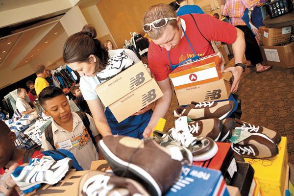 Volunteers Christine Doerhoff and Erich Topp help Oliver, 9, pick out new shoes at NCJWs 2009 Back to School Store. 