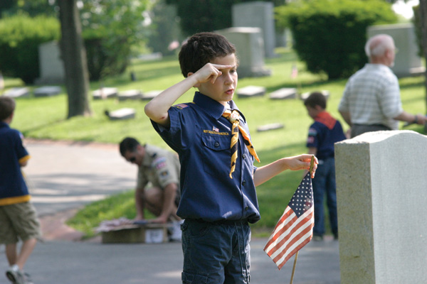 Andy Mesnier salutes after placing a new American flag at the grave of a veteran at New Mount Sinai Cemetery on Sunday morning. Mesnier, of Troop 982, based at Sorrento Springs Elementary School in Ballwin, was one of close to 100 Boy Scouts who came to the cemetery to place flags. Boy Scouts from Troop 11, based at Temple Israel also participated. About 275 scouts visited each Jewish cemetery on Sunday. 
