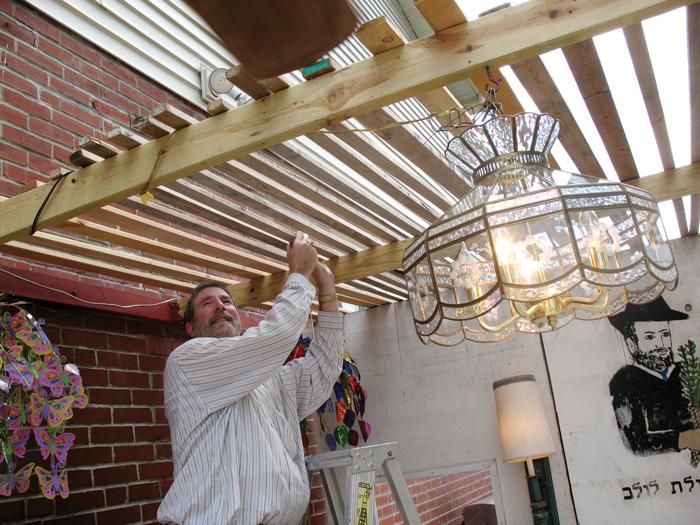 Mark Abrams works on his family's sukkah at their University City home. 