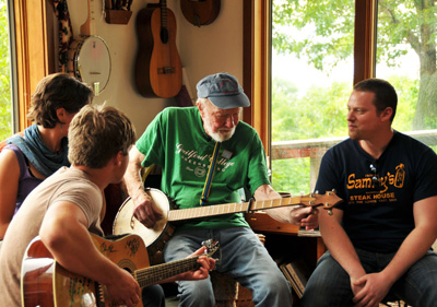 Folk singer Pete Seeger, in green, records a song at his home in Beacon, N.Y. in May 2010 for an Israeli-organized peace rally. He is accompanied by Walker Rumpf on guitar and Arava Institute for Environmental Studies alumni Zack Korenstein and Sarah Schuldenfrei. 