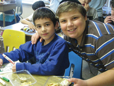 Epstein Hebrew Academy middle school student Simcha Fremerman welcomes lower school student Yechiel Shulman during Epstein Hebrew Academy’s Baruch Habayim program. During the week of Parshas Vayeira (where Abraham displays his remarkable attribute of welcoming guests), EHA lower and middle school students were encouraged to reach out to each other with  treats and special hand-made notes to learn this important lesson.