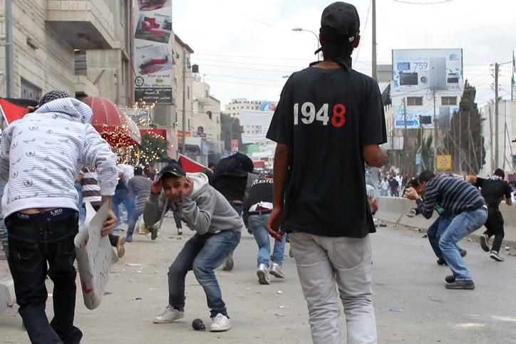 Stone-throwing Palestinians clash with Israeli troops near the Kalandiya checkpoint between the West Bank city of Ramallah and Jerusalem on the 63rd anniversary of the Nakba, May 15, 2011. 