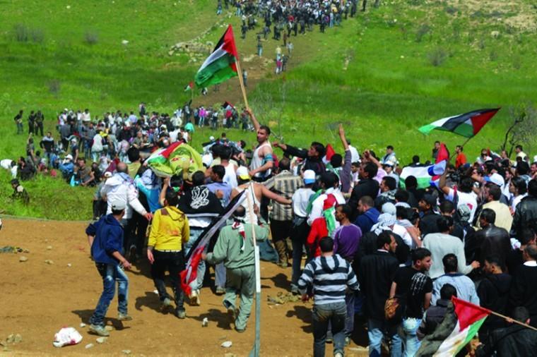 Arab demonstrators marking the 63rd anniversary of the Nakba hold Palestinian flags as they approach the village of Majdal Shams in the Golan Heights, between Syria and Israel on May 15. Photo: Hamad Almakt/Flash90/JTA