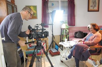 Ruth Farhi, who was a student in Jerusalem in 1948, sits in her Ramat Gan home for an interview with cameraman Peleg Levy of Toldot Yisrael, which is documenting personal recollections of Israel’s War of Independence. (Dina Kraft)