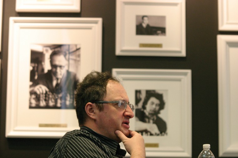 
Seated in front of a
wall of portraits of chess legends, Israeli Grandmaster Boris
Gelfand speaks at the Chess Club and Scholastic Center of Saint
Louis, located in the Central West End. Photo: Mike
Sherwin
