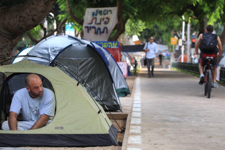 Young israelis seen near tents set up on Rothschild Avenue in
Tel Aviv. Fed up with high housing prices around the country,
hundreds set up tent city, vow to stay until government presents a
solution. July 26 2011. Photo by Liron Almog/Flash90. 

