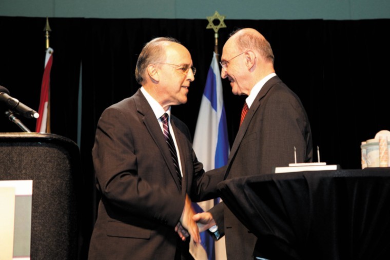 From left, Federation President and CEO Barry Rosenberg shakes
hands with outgoing Federation Board President Sanford Neuman.
