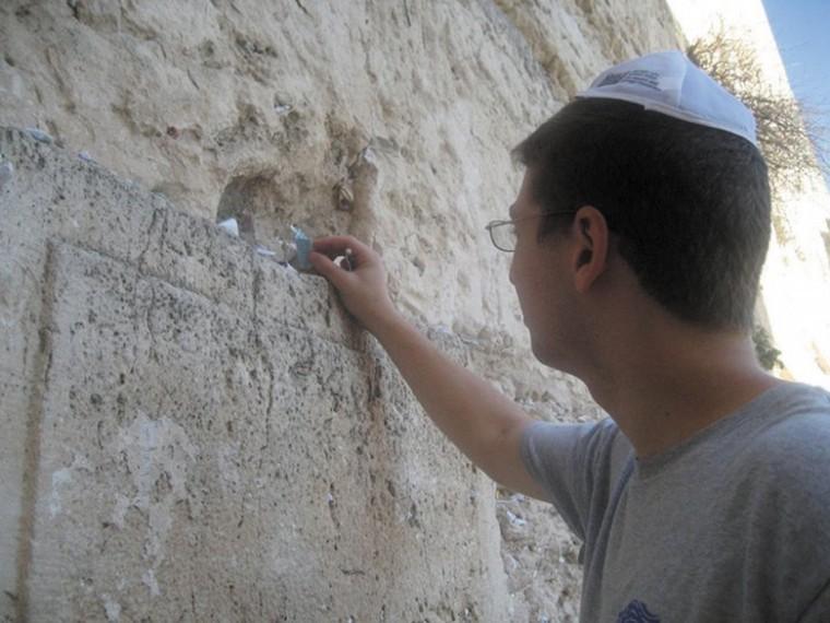 While on his trip to Israel, senior Jake Weisman places a
message on the historic Western Wall. Weisman spent three weeks
traveling the country this summer.
