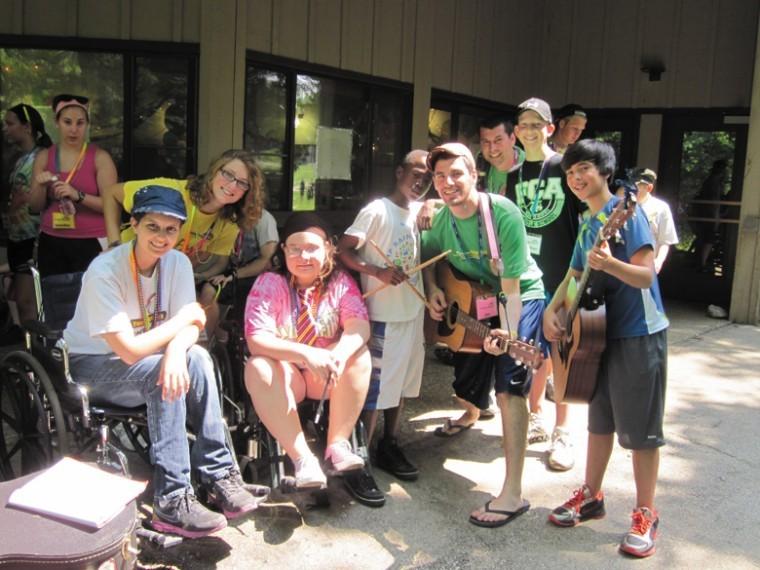 Josh Mannis, right (blue shirt, holding guitar), chose to
volunteer at Camp Rainbow, a sleepover camp for children with
cancer, for his mitzvah project. Mannis collected donations of new
or gently used musical instruments for the campers.
