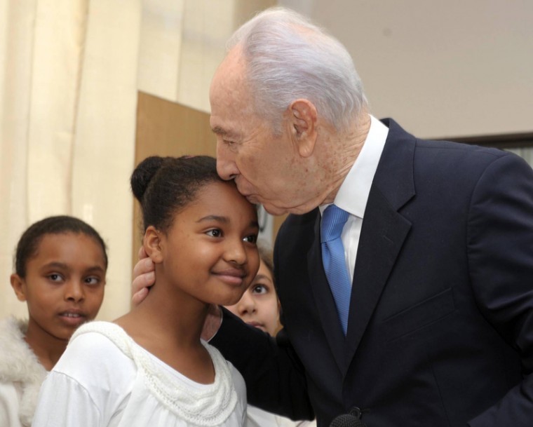 President Shimon Peres has a kiss for an Ethiopian student at
the Amit Reishit School in Jerusalem, where he was inspired to
write a song in tribute to the Ethiopian Israeli community after
listening to the schools choir, Jan. 12, 2012. (Mark
Neyman/GPO/Flash 90)
