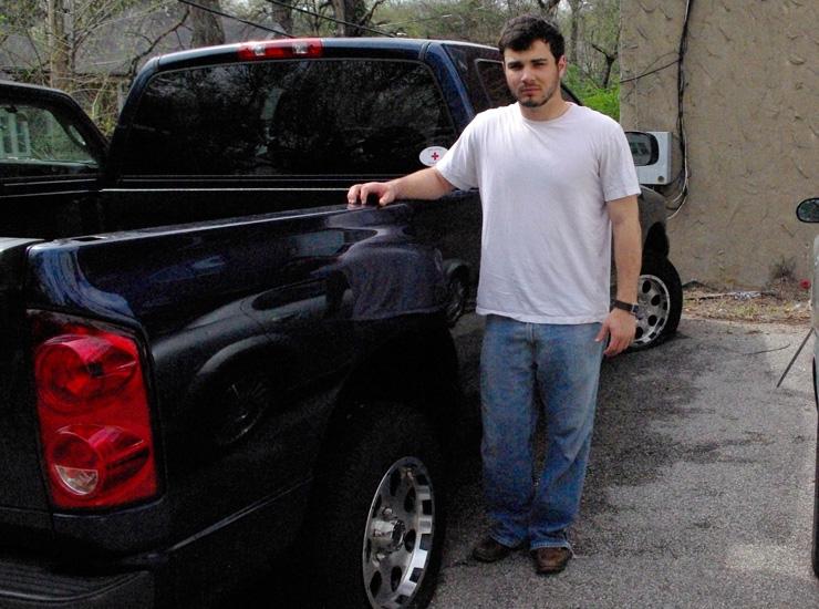 Washington University student Max LaVictoire stands by his Dodge Ram 1500, which was vandalized while he was out of town over spring break. All four tires on his truck had been slashed and two swastikas had been keyed into the body of the vehicle. Photo: Ellen Futterman
