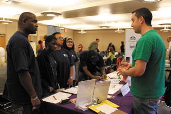 A representative from Big Brothers Big Sisters talks with visitors to last year’s Community Against Poverty Volunteer Fair.
