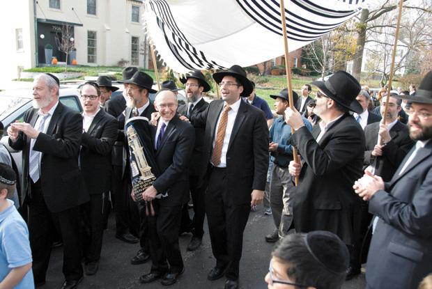 Stanley Jacobs carries U.City Shul’s new Torah during the Thanksgiving Day procession. U.City Shul Rabbi Menachem Tendler is at Jacobs’ right. Photo: Don Meissner
