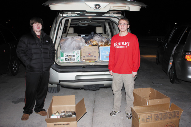 At Whole Foods, Nate Noss (right) and a volunteer stand beside food that would normally be wasted, but will instead go to charity. Photo by Lily Siwak
