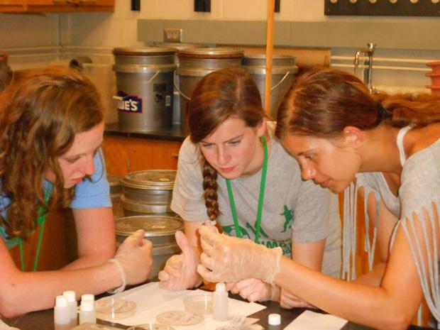 At the science camp Girls Go Green, Julia Goldman (center) works on a science research project.
