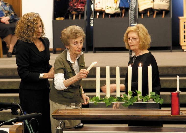 Margi Lenga Kahn, left, with her mother, Ann Lenga, light a candle during the 2011 Yom HaShoah Community Commemoration. 
