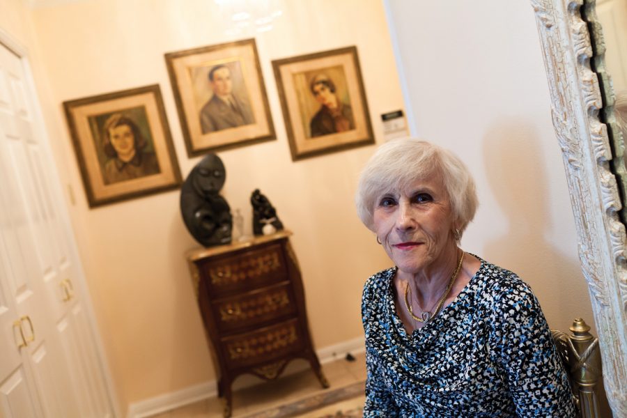 Rachel Miller at home, in front of paintings of three of her family members lost during the Holocaust— her mother, father and sister. A German prisoner of war created the portraits, working from photographs of the family. Photos: Lisa Mandel