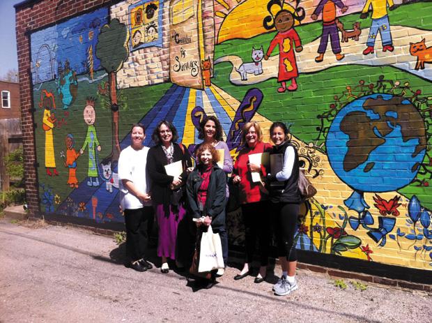 Kristin Builn (left), Executive Director of the Center for Survivors of Torture and War Trauma, stands with members of the Jewish Fund for Human Needs selection committee in front of a mural painted by clients of the center. The center received a $2,500 grant from JFHN.