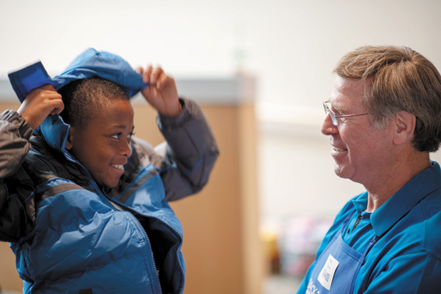 Volunteer Marty Oberman, right, helps Yaheed McCurry pick out his new coat for the school year during NCJW’s Back to School Store in 2012.  The NCJW event serves more than 1,200 children. 