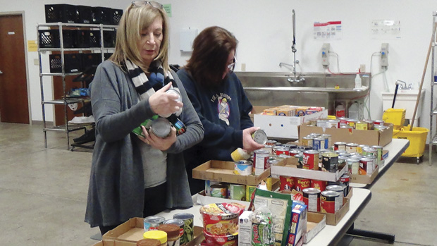 Peggy Musen (left) and Jane Rapp volunteer at the Harvey Kornblum Jewish Food Pantry on Friday. The food pantry is seeking donations from the community to help it keep up with record levels of demand. 