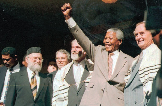 Nelson+Mandela+salutes+the+crowd+at+the+Green+and+Sea+Point+Hebrew+Congregation+in+Cape+Town+on+a+visit+shortly+after+being+elected+South+Africa%E2%80%99s+president+in+1994.+Joining+Mandela%2C+from+left%2C+are+Rabbi+Jack+Steinhorn%3B+Israel%E2%80%99s+ambassador+to+South+Africa%2C+Alon+Liel%3B+Chief+Rabbi+Cyril+Harris%3B+and+Mervyn+Smith%2C+chairman+of+the+South+African+Jewish+Board+of+Deputies.+Photo%3A+SA+Rochlin+Archives%2C+SAJBD%C2%A0
