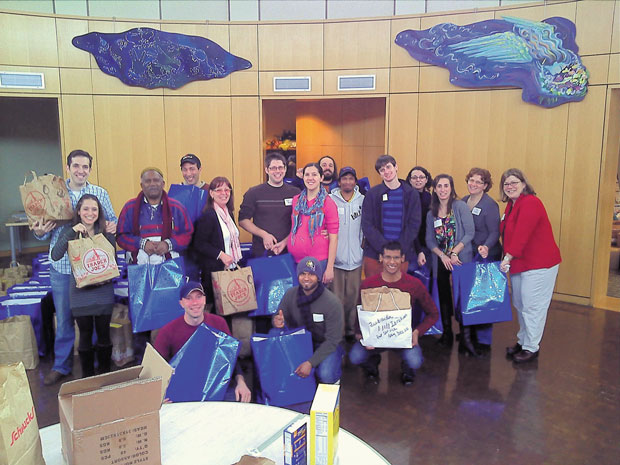 One group of volunteers attending last year’s Jewish and Muslim Christmas Day of Service gathered at Central Reform Congregation  and packed 90 bags of food for the Gateway 180 homeless shelter.  Photo: Abbas Ali 