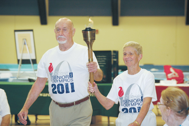 Bill Cannon and Dottie Gray carry the torch at the opening ceremonies of the 2011 St. Louis Senior Olympics held at the Jewish Community Center in Creve Coeur.  