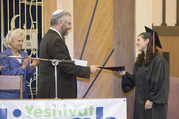 Rabbi Moshe Shulman presents Yeshivat Kadimah High School’s first graduate, Hadassah Cohen, her diploma during a commencement ceremony last week at Nusach Hari B'nai Zion. Photo: Kristi Foster 