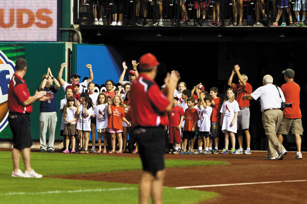 A choir of children sing “Take Me Out to the Ball Game” along with Rick Recht on the field at Busch Stadium during last year’s Jewish Community Day at the ballpark. This year’s event takes place Aug. 17. File photo: Lisa Mandel 