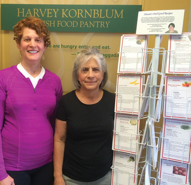 Julie Eisenberg (left), project creator and chair, with Marcia Mermelstein, Jewish Food Pantry outreach coordinator, showcase ‘Naomi’s Feel Good Recipes’ display. 