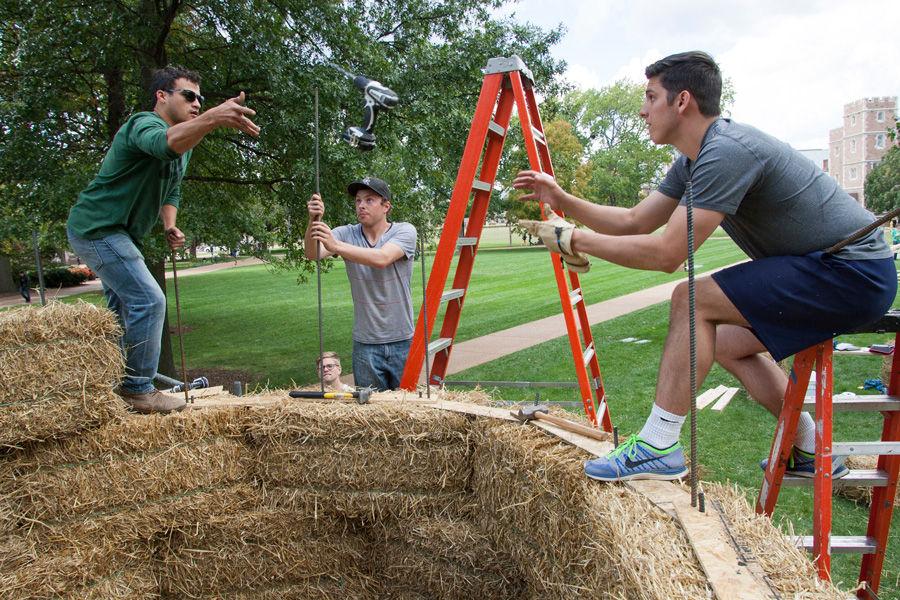 Working+7-feet+up+atop+a+sukkah+made+of+hay+bales%2C+Devin+Brown+%28left%29+tosses+a+cordless+drill+to+Brandon+Eversgerd+as+Eric+Dernbach+works+on+the+rebar+support+structure.+All+are+architecture+students+at+Kansas+State.+The+design+%28by+Brown%29+was+one+10+winners+in+the+Sukkah+City+STL+competition+held+by+Washington+University+and+St.+Louis+Hillel.