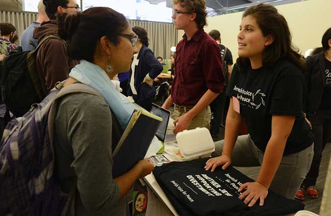 
Various organizations tabled at a fair held Sunday at the Open Hillel conference. Above, a student talks to an organizer with Jewish Voice for Peace. Photo: Gili Getz
