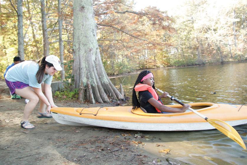 Mizzou student Ruby Ficklen launches Taija, a sixth grade student in the Riverview Gardens School District, in a kayak on Saturday afternoon at Camp Manitowa in Southern Illinois. Taija was one of 22 middle school students who live on Canfield Drive in Ferguson and were invited to the camp for the weekend. Photo: Mike Sherwin