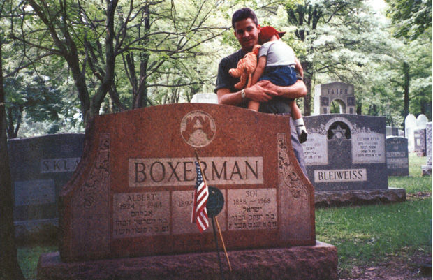 In 1999 at Chesed Shel Emeth Cemetery, Bill Blumenthal holds his son, then age 2, while visiting the grave site of Albert Boxerman, who was killed at age 19 in World War II. Boxerman was the cousin of Bill’s father, Harvey Blumenthal.  