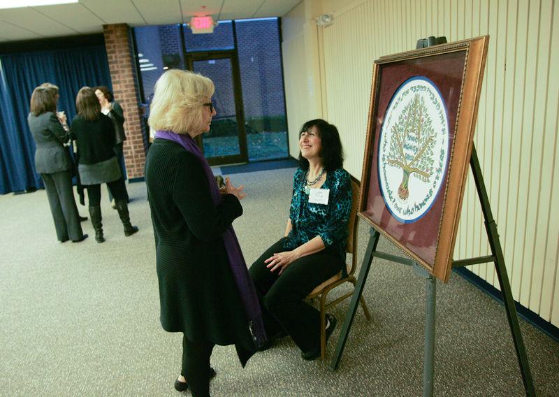 Artist Tsila Schwartz (seated) talks with Marcia Goldberg during the artists reception and Havdalah, held Nov. 22. Schwartz and Unell (above) created  artwork exploring the middah of ‘kavod,’ (honor, respect or dignity). 