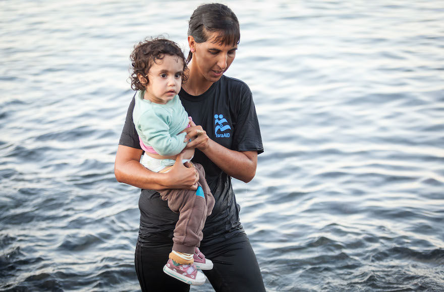 Tali+Shaltiel%2C+an+Israeli+physician%2C+taking+a+Syrian+child+from+a+dinghy+that+arrived+at+a+beach+on+the+Greek+island+of+Lesbos.+Photo%3A+Boaz+Arad%2FIsraAid
