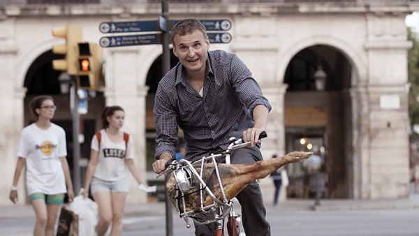 Phil+Rosenthal+bikes+with+a+ham+in+Barcelona+in+%E2%80%9CI%E2%80%99ll+Have+What+Phil%E2%80%99s+Having.%E2%80%9D%C2%A0+Photo+courtesy+WGBH