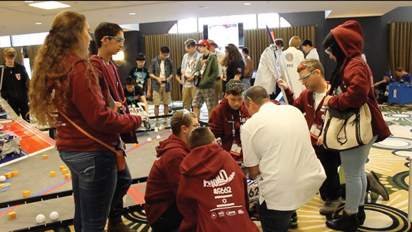 (From right) Taima Sawaed, an Arab high school student and Ofer Rubin, an Israeli teacher, look on as their team prepares a robot for competition. Photos: Eric Berger