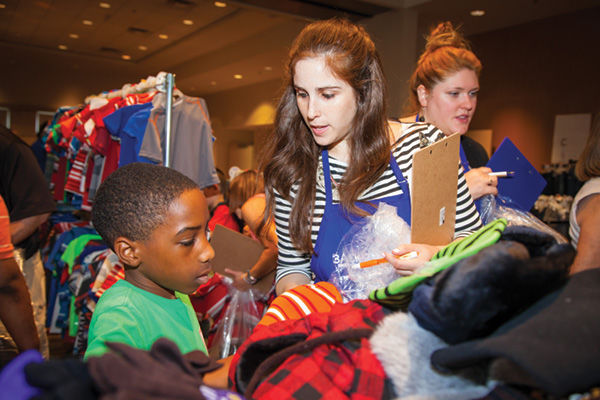 A volunteer helps a child select items at last year’s Back to School! Store, held at Central Reform Congregation. This year, the event takes place at Temple Israel. Photo: Kristi Foster
