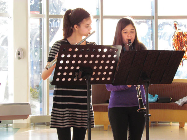 As a part of her mitzvah project, Daphne Levy (left) plays the flute during a performance at Ranken Jordan Pediatric Bridge Hospital. Her sister, Evyn, plays clarinet, at right.