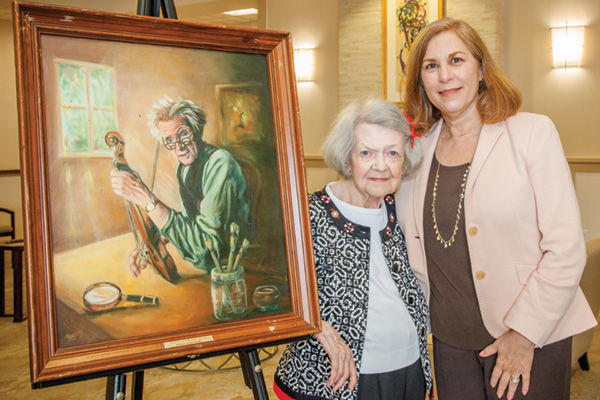 Covenant Place resident Rosy Weinstein (left) stands with a painting she created and donated to the Jewish Center for Aged many years ago.  The painting, which Weinstein had not seen since the 1980s, was part of the JCA’s collection of artwork  donated to Covenant Place. Joan Denison, executive director of Covenant Place, is shown at right. Photo: Joan Denison