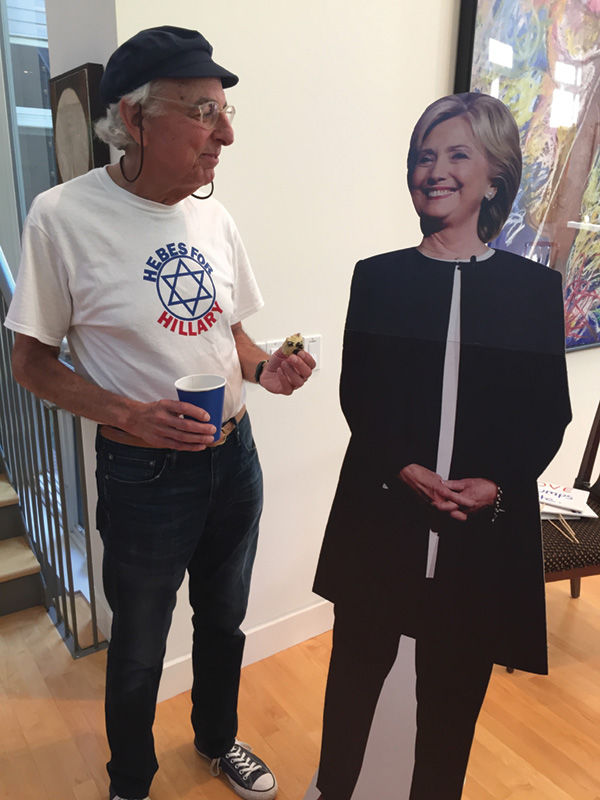 Dr. Marshall Poger shows off his “Hebes for Hillary” T-shirt, which he designed, to a virtual Hillary Clinton, Democratic nominee for president.