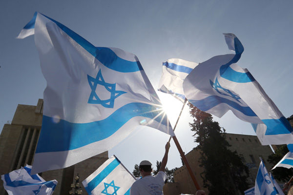 Israelis celebrate Jerusalem Day in 2013 by waving flags as they walk to the Western Wall in Jerusalem.  File photo: Nati Shohat/Flash90