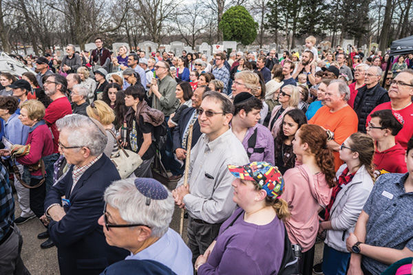 Estimates of up to 2,500 people gathered at Chesed Shel Emeth on Feb. 22 to help in a cleanup effort at the cemetery. Here the group listens to remarks by Gov. Eric Greitens, who put out a call on social media for volunteers to join him in a show of community support after 154 headstones were overturned or broken at the cemetery. Photo: James Griesedieck