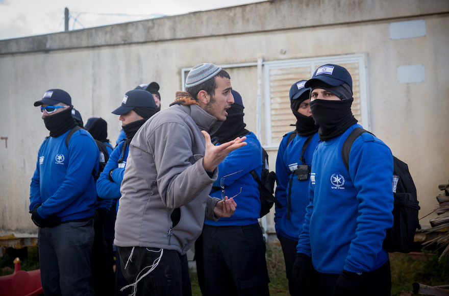An Israeli settler argues with police officers evacuating the West Bank outpost of Amona, Feb. 1, 2107. (Miriam Alster/Flash90)