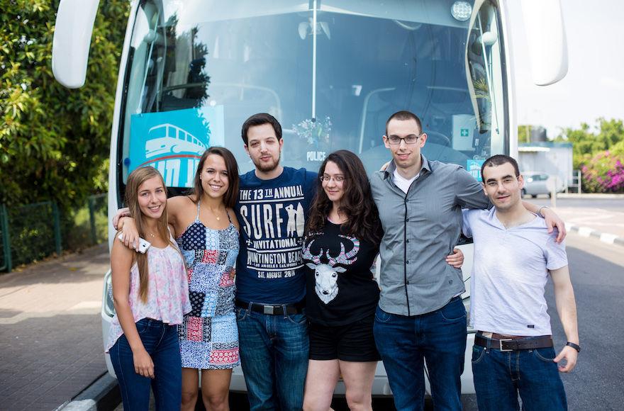 Noa Tnua founder Roy Schwartz Tichon, second from right, and board member Noam Tel-Verem, third from right, posing with volunteers before the launch of their bus service in Ramat Gan, Israel, June 6, 2015. (Avihai Levy)