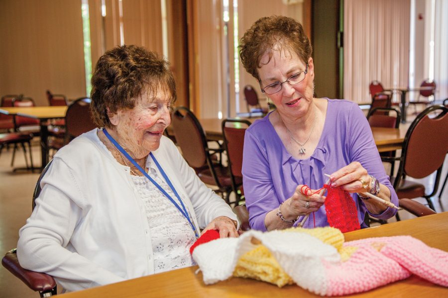 Above, Jerri Livingston (right) works with a participant of Covenant Places knitting group. Livingston also leads Shabbat services at Covenant and at the Brentmoor. Photo: Kristi Foster