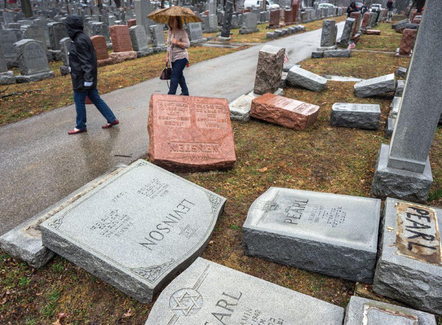 The morning of Feb. 20, people look over the toppled gravestones at Chesed Shel Emeth Cemetery in University City. The U. City Police say they are still investigating but have made no arrests in the case. Photo: James Griesedieck