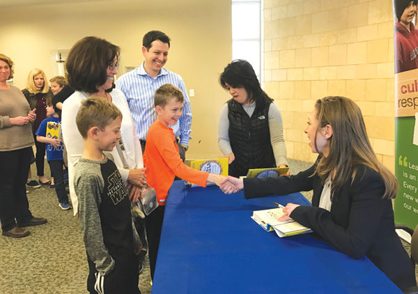 Chelsea Clinton, who visited Saul Mirowitz Jewish Community School on April 7, signs the book of students. Photo by Patty Bloom.