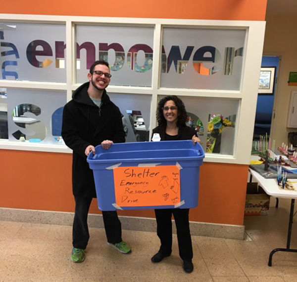 Andrew Brick and Saul Mirowitz Jewish Community School head of school Cheryl Maayan hold a donations bin.